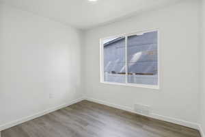 Empty room with baseboards and wood finished floors