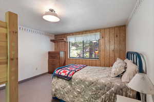 Bedroom with wooden walls and carpet