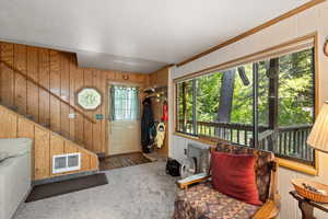 Foyer entrance with carpet, wood walls, and stairs