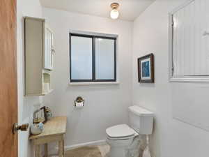 Bathroom featuring toilet and baseboards