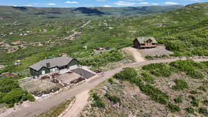 Aerial view of property and surrounding area with a mountain backdrop