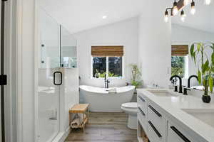 Bathroom featuring a  double vanity, a stall shower, and a soaking tub
