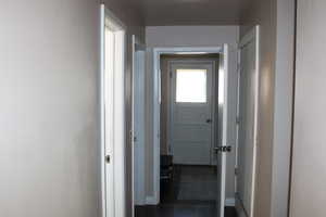Corridor featuring baseboards and laminate flooring