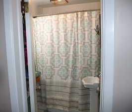 Full bathroom featuring curtained shower and a sink