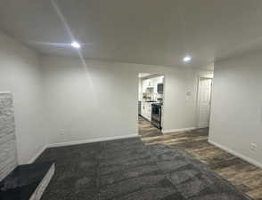Below grade area with dark wood-type flooring and recessed lighting