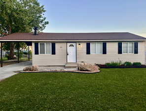 Ranch-style house featuring an attached carport, driveway, and roof with shingles