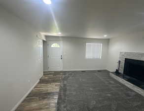 Unfurnished living room featuring a fireplace, dark wood finished floors, plenty of natural light, and recessed lighting