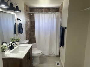 Bathroom featuring vanity, shower / tub combo with curtain, and tile patterned floors