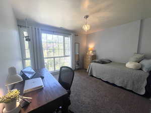 Carpeted bedroom with a desk