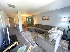 Living room featuring a chandelier and carpet