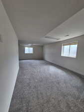 Carpeted empty room featuring plenty of natural light and a textured ceiling