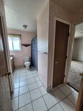 Bathroom with vanity, tile patterned floors, a textured ceiling, and curtained shower