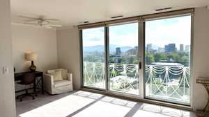 Entryway featuring a skyline view, plenty of natural light, carpet floors, crown molding, and a ceiling fan
