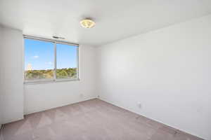 Spare room featuring light carpet and baseboards