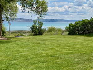 Grass yard with  water view with a mountainous background