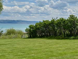 View of grassy yard featuring a water and mountain view
