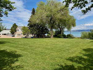 View of grassy yard with a water view
