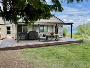 Side view of house with a lawn and a wooden deck