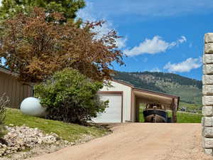 Garage with gravel driveway and a mountain view