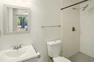 Full bathroom featuring a tile shower and vanity