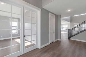 Foyer featuring wood finished floors, stairs, and recessed lighting