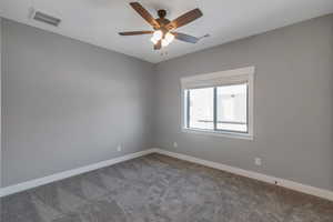 Spare room with carpet floors and a ceiling fan