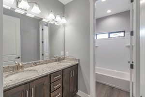 Full bath with double vanity and wood finished floors