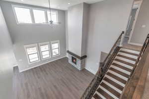 Unfurnished living room featuring a ceiling fan, wood finished floors, a glass covered fireplace, healthy amount of natural light, and recessed lighting