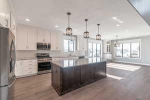 Kitchen featuring stainless steel appliances, tasteful backsplash, white cabinets, and recessed lighting