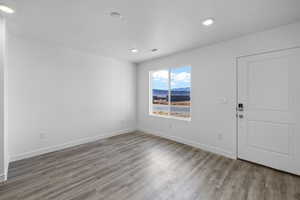 Empty room with wood finished floors and recessed lighting