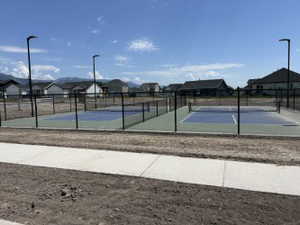 View of tennis court with a residential view