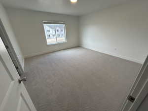 Carpeted empty room featuring baseboards