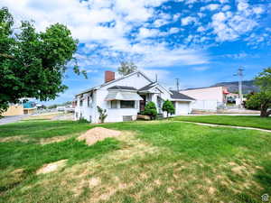 Bungalow featuring a chimney and a front yard