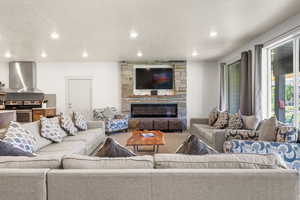 Living area featuring a stone fireplace and natural light