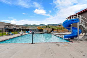 Waterdance Rec Center  pool featuring a water slide, a mountain view, and a patio