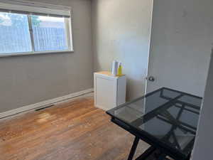 Office with wood-type flooring and a textured wall