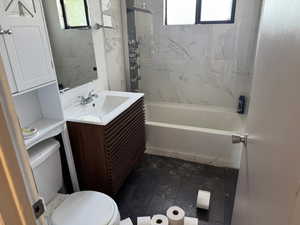 Bathroom with vanity, plenty of natural light, shower / tub combination, and wood finished floors
