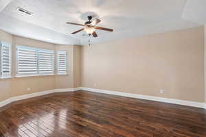 Empty room featuring a ceiling fan, hardwood / wood-style flooring, and a textured ceiling