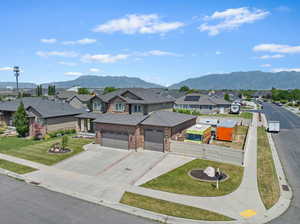 View of front of property featuring an attached garage, a residential view, brick siding, and a mountain view