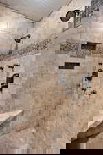 Bathroom featuring tiled shower and a textured ceiling