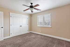 Unfurnished bedroom with carpet, a closet, and ceiling fan