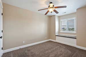 Bedroom with dark carpet and ceiling fan