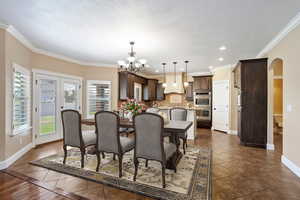 (Virtual Staging) Dining area with arched walkways, a chandelier, recessed lighting, dark tile patterned floors, and a textured ceiling