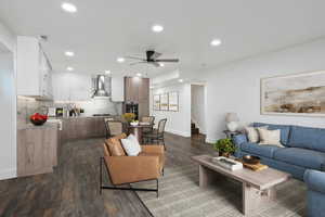 (Virtual Staging) Living area with ceiling fan, dark wood finished floors, stairs, and recessed lighting