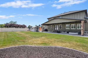 Rear view of house featuring board and batten siding, a patio area, a shed, a fenced backyard, and entry steps