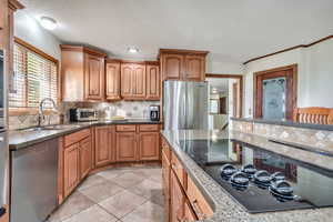 Kitchen featuring stainless steel appliances, island with built-in seating, tasteful backsplash, and plenty of natural light