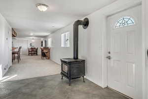 Separate basement entrance featuring a wood stove, and plenty of natural light