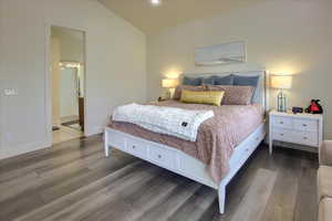 Bedroom featuring wood finished floors, vaulted ceiling, and recessed lighting