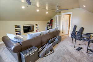 Cinema with ceiling fan, carpet flooring, lofted ceiling, built in features, and recessed lighting