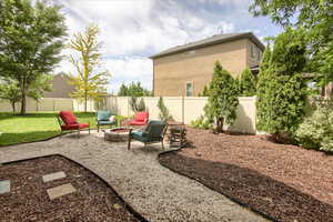 Fenced backyard featuring an outdoor fire pit and a patio